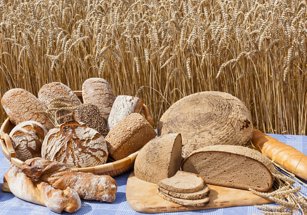 Verschiedene Brotsorten vor Kornfeld