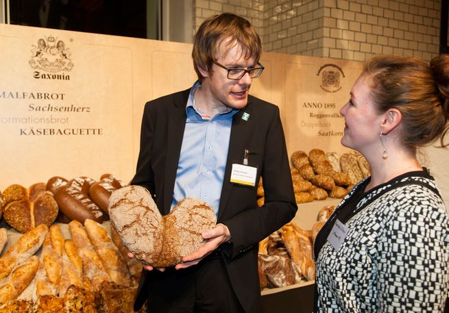 Junger Mann präsentiert zwei Brote