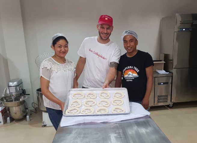 Bäckermeister Michael Moll backt mit Nepalesen Brezeln.
