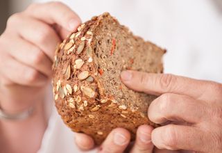 Prüfer drückt auf Brot