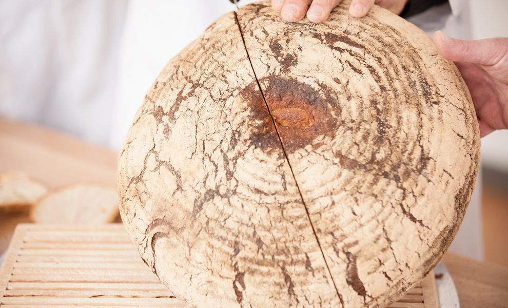 Brot wird von einem Brotprüfer geteilt