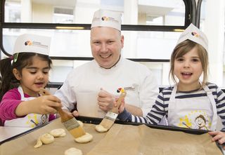 Bäcker backt mit Kindern Plätzchen