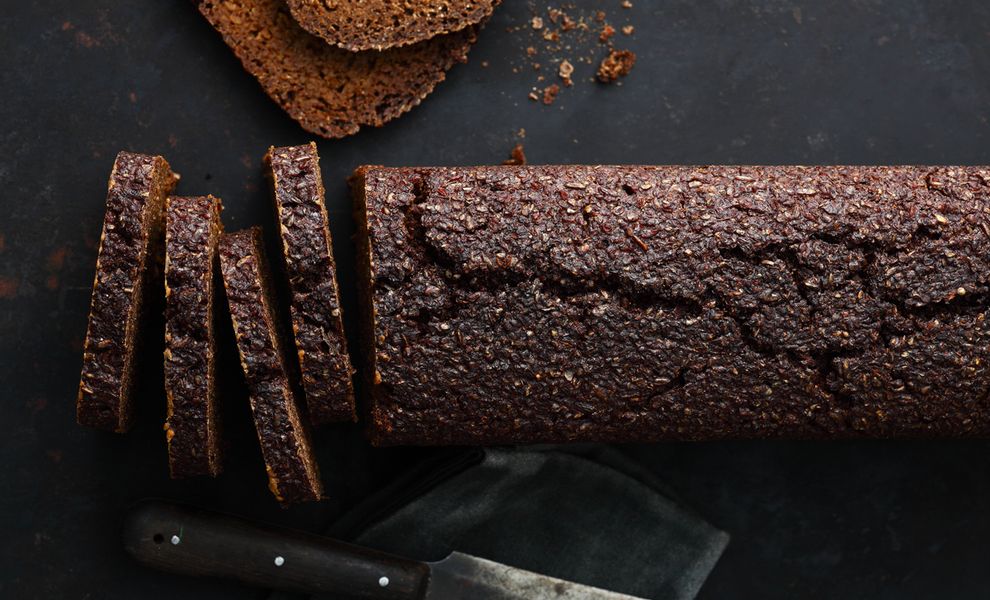 Angeschnittenes Pumpernickel Brot auf Schiefer