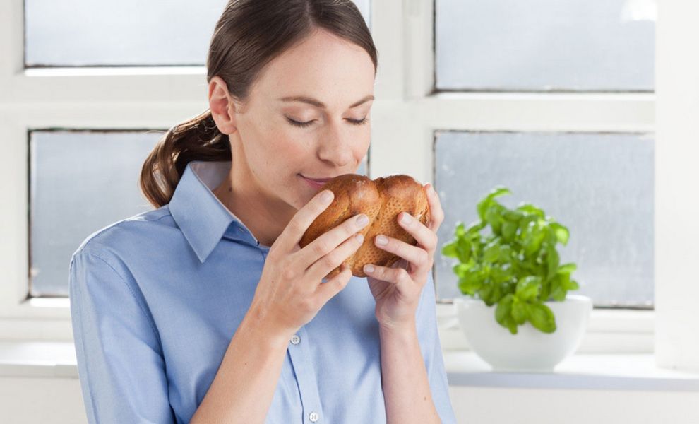 Frau riecht an frisch aufgetautem Brot