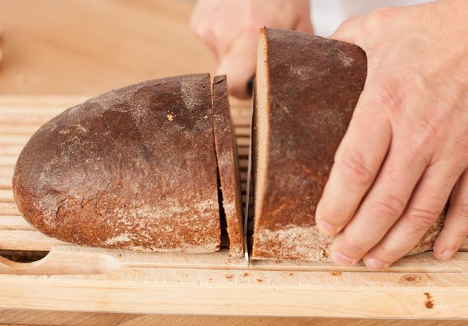 Bäcker schneidet Brot