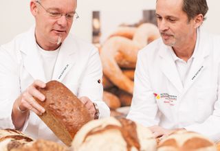 Zwei Brotprüfer schauen sich ein Brot an